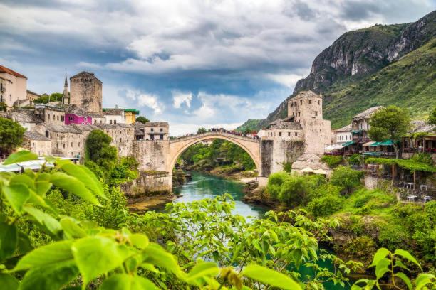 un pont sur une rivière à côté d'une montagne dans l'établissement Lovely Bosnian Home, à Mostar