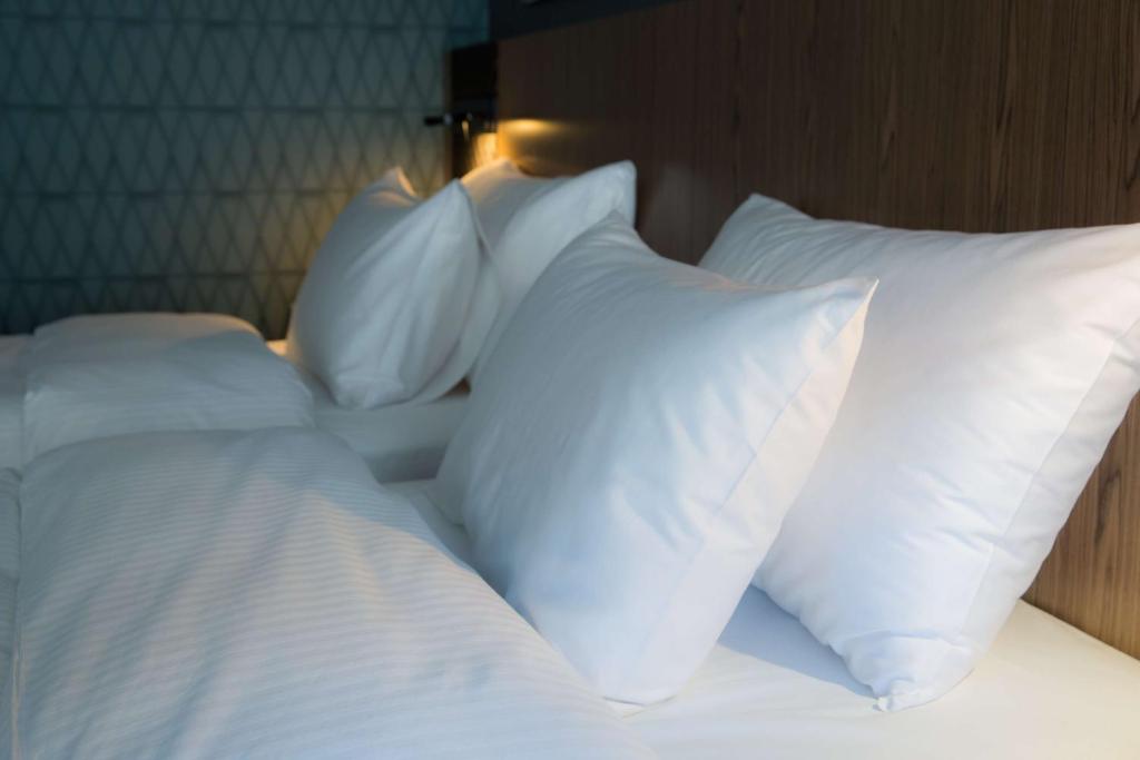 un grupo de almohadas blancas en una cama en Radisson Blu Kochi, en Kochi