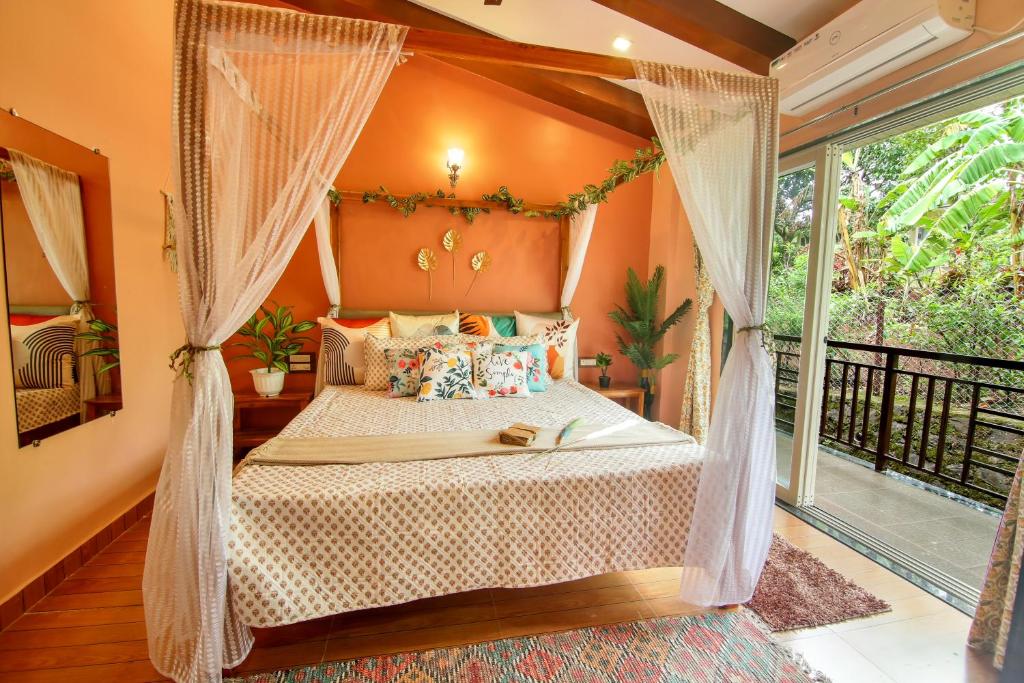 una camera con letto a baldacchino e balcone di Elsewhere Villa by Hill Staytion a Mahabaleshwar