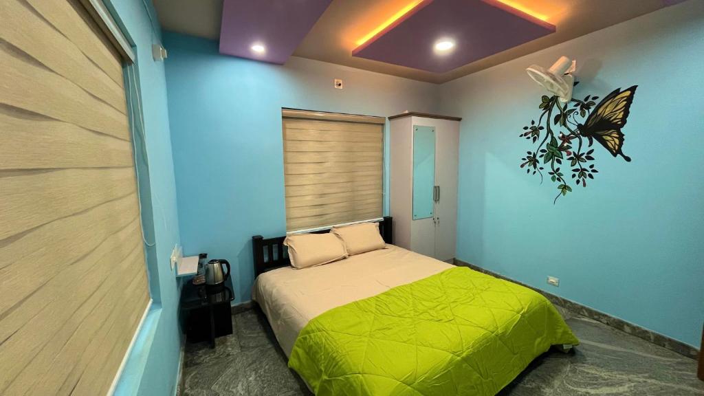 a bedroom with a bed with a butterfly on the wall at Welldone Wayanad Holidays in Sultan Bathery