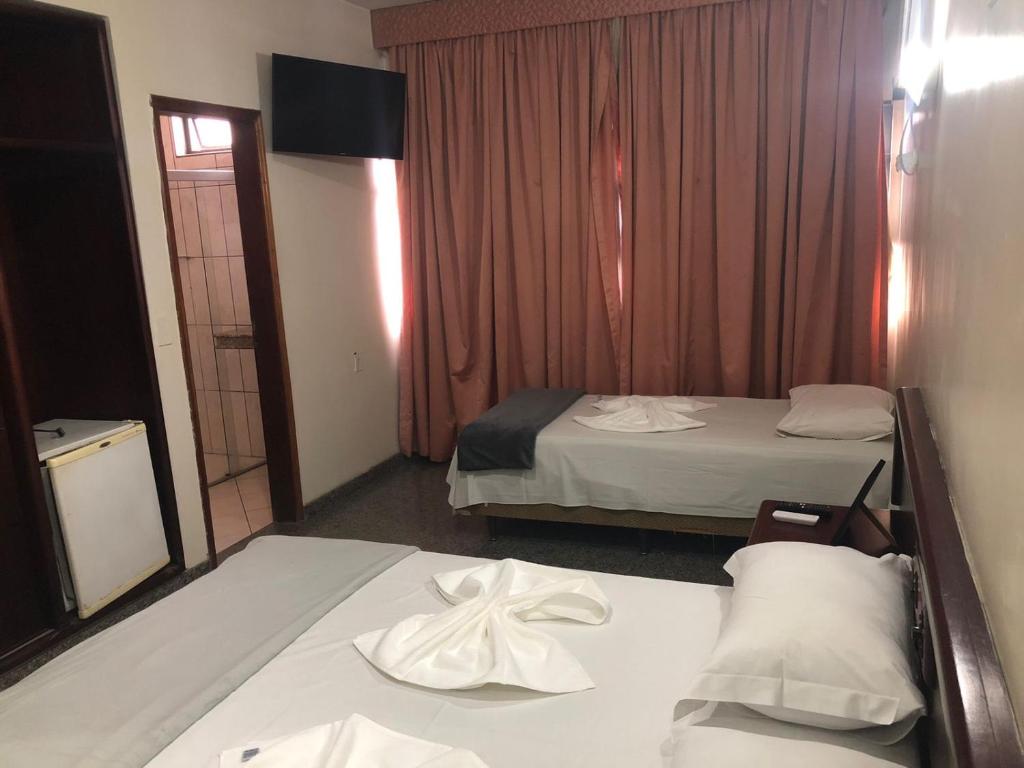 um quarto de hotel com duas camas e uma janela em Avalon Executive em Goiânia