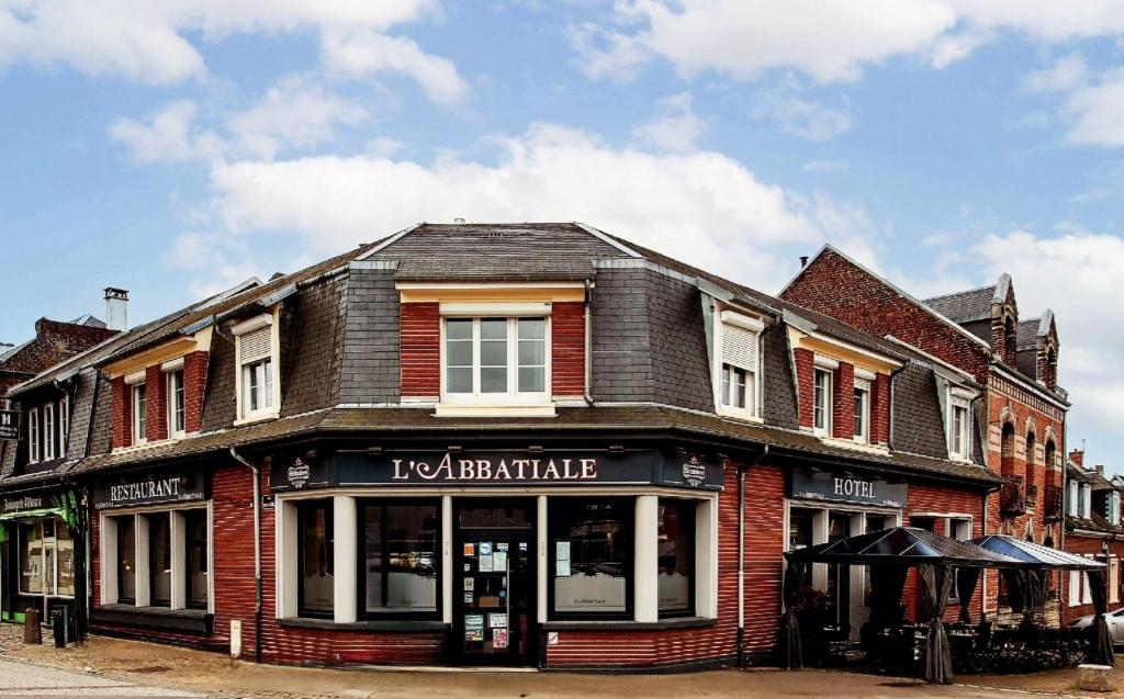 a red brick building on a city street at L'abbatiale in Corbie