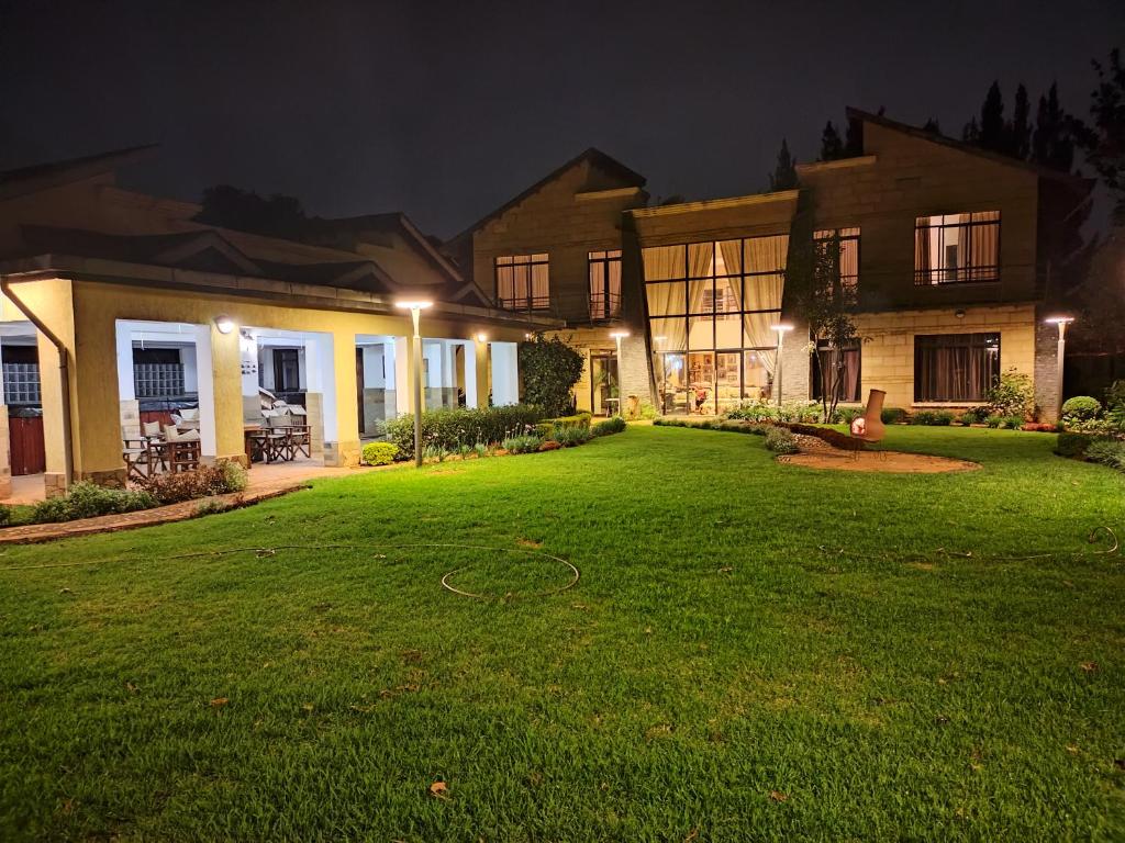 een huis met een groene tuin 's nachts bij Florances Rest House in Nairobi