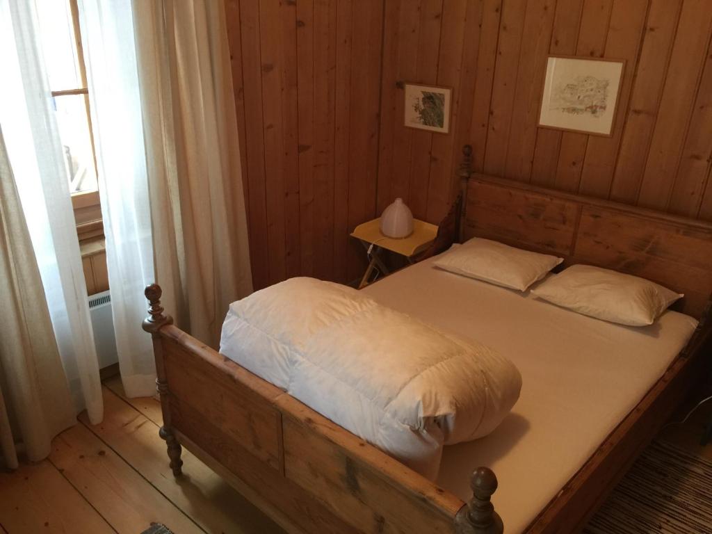 ein Schlafzimmer mit einem Bett in einem Holzzimmer in der Unterkunft Roccabella in Bivio