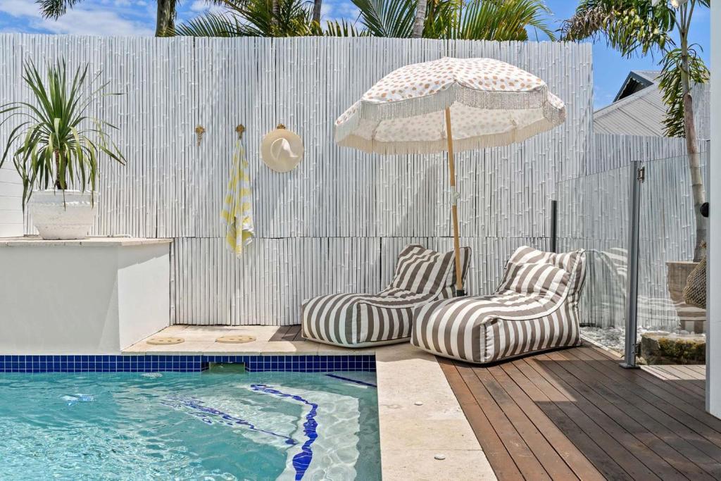 due sedie e un ombrellone accanto alla piscina di Salta a Byron Bay