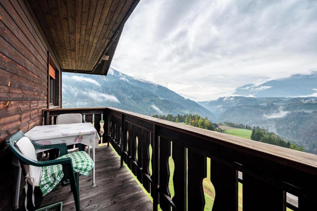 un balcone di una cabina con tavolo e sedie di Ferienwohnung Gatscherhof a Luson