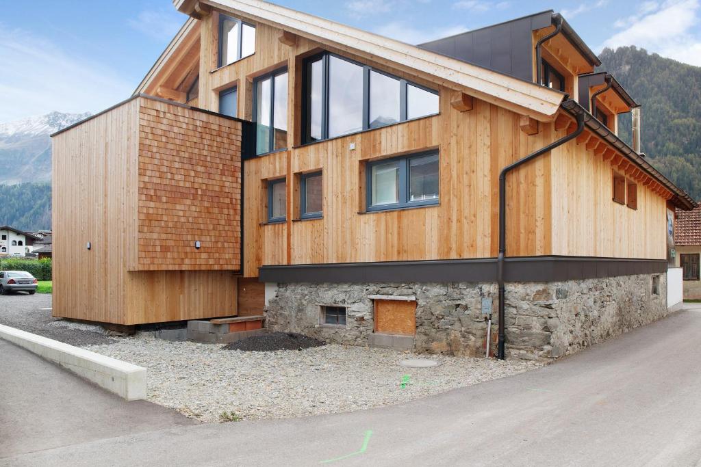 una casa in legno con un muro in pietra di Apartement Bens Auszeit Top 6 a Umhausen