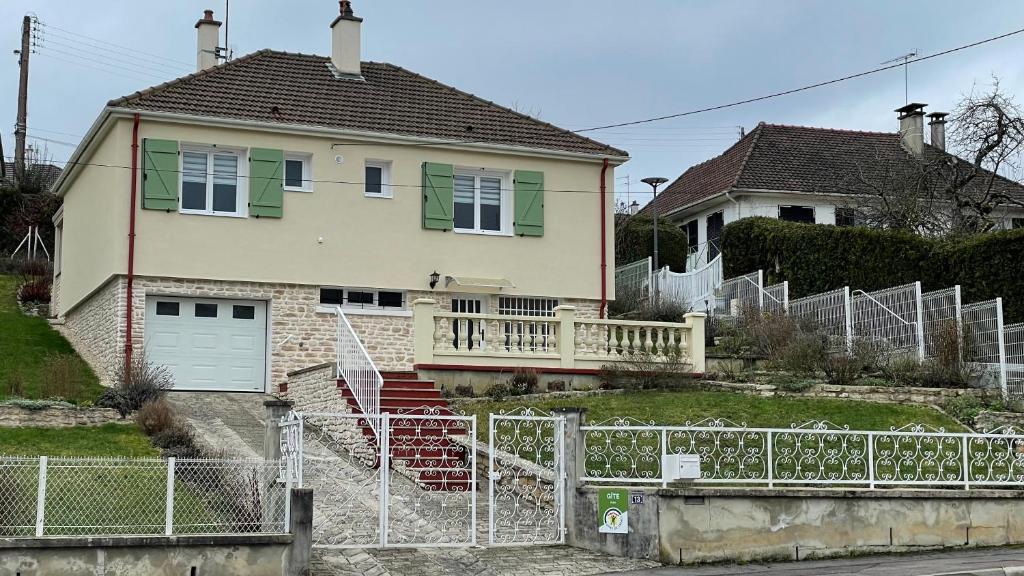 a house with a white fence in front of it at LES GRADINES in Bar-sur-Aube