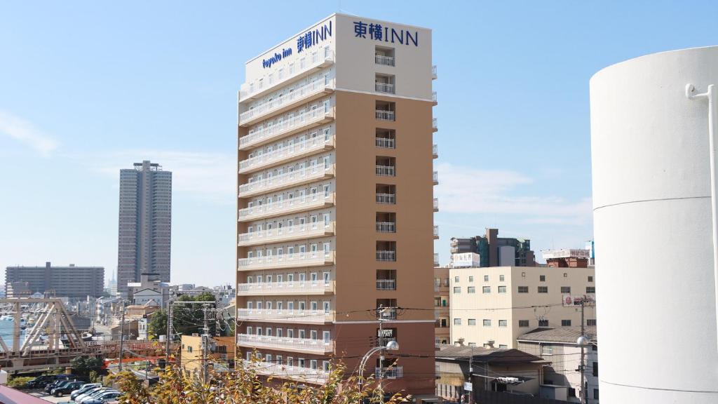 ein hohes Gebäude mit einem Schild darüber in der Unterkunft Toyoko Inn Osaka Dome Mae in Osaka