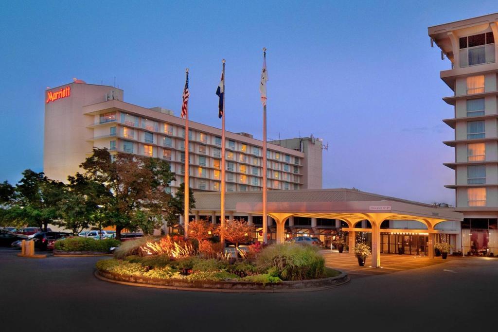 un hotel con dos banderas frente a un edificio en Marriott St. Louis Airport, en Edmundson