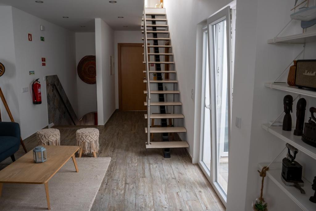 una sala de estar con una escalera de caracol junto a una ventana en Tavira Nomad Guesthouse, en Tavira