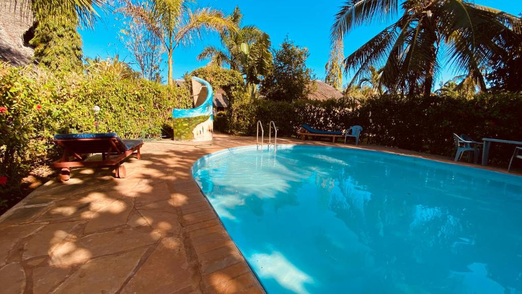 - une piscine dans une cour avec 2 chaises et des arbres dans l'établissement Villas Dora and Holly, à Diani Beach