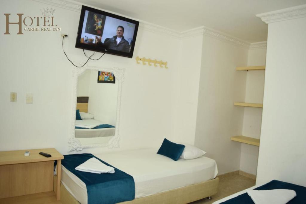 una camera con letto e TV a parete di Hotel Caribe Real Inn a Santa Marta