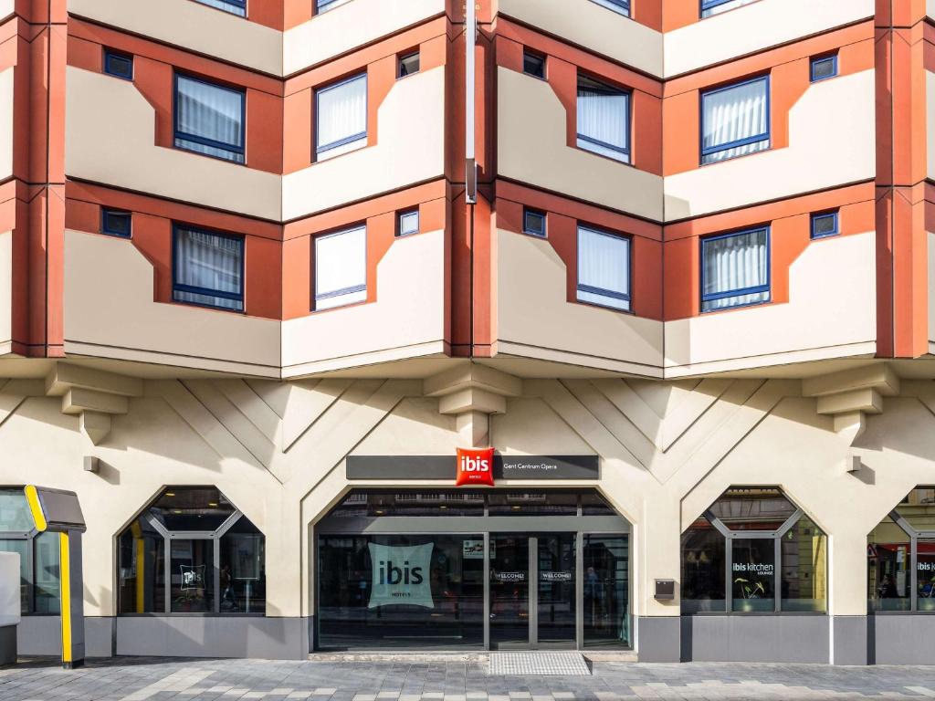 un grande edificio con un cartello di autobus di fronte di ibis Gent Centrum Opera a Gand