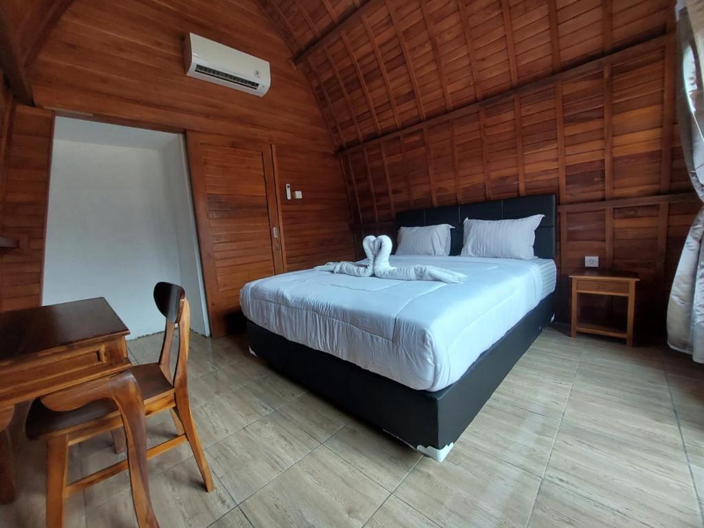 a bedroom with a bed and a table and a desk at Les Chalets Pecatu in Uluwatu