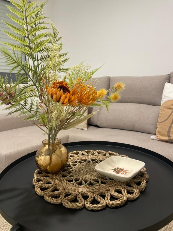 einen Couchtisch mit einer Vase mit Blumen darauf in der Unterkunft Modern Spacious Apartment in Entroncamento