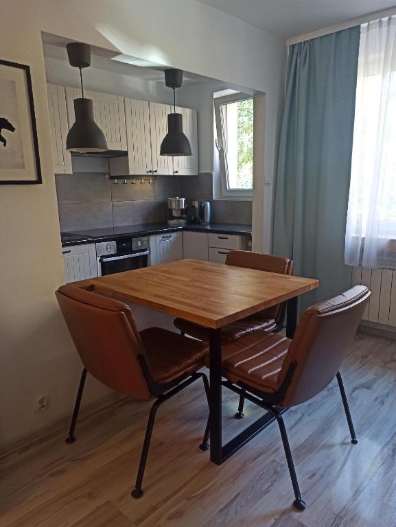 a kitchen with a wooden table and two chairs at Na Sadowej in Grodzisk Mazowiecki