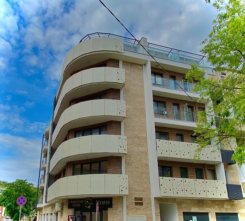 ein großes Apartmenthaus mit einem Himmel in der Unterkunft AVRORA SUITE in Warna