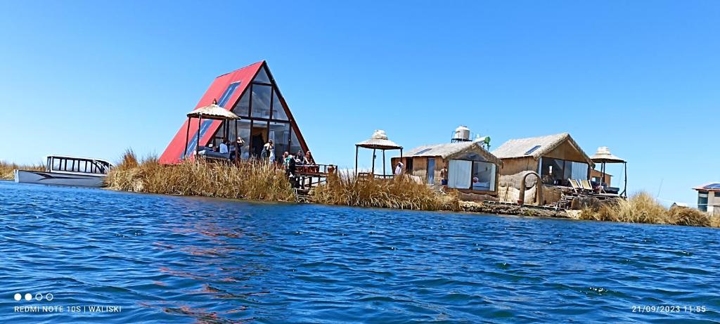 a group of houses on an island in the water at Uros Waliski Lodge in Puno