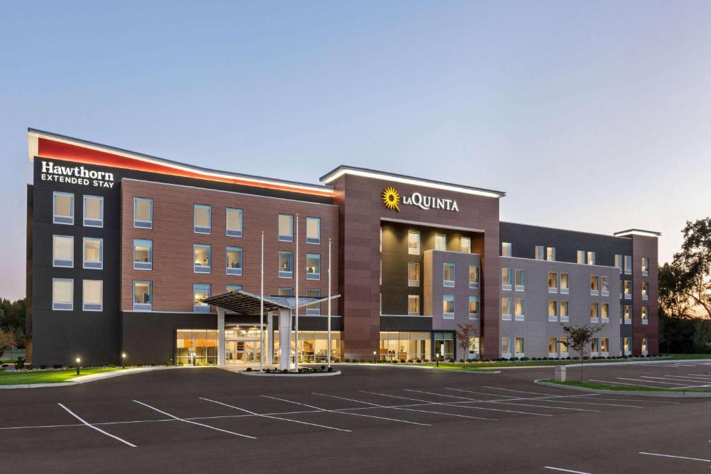 劳雷尔山La Quinta Inn & Suites by Wyndham Mount Laurel Moorestown的一座大型建筑,前面设有停车场