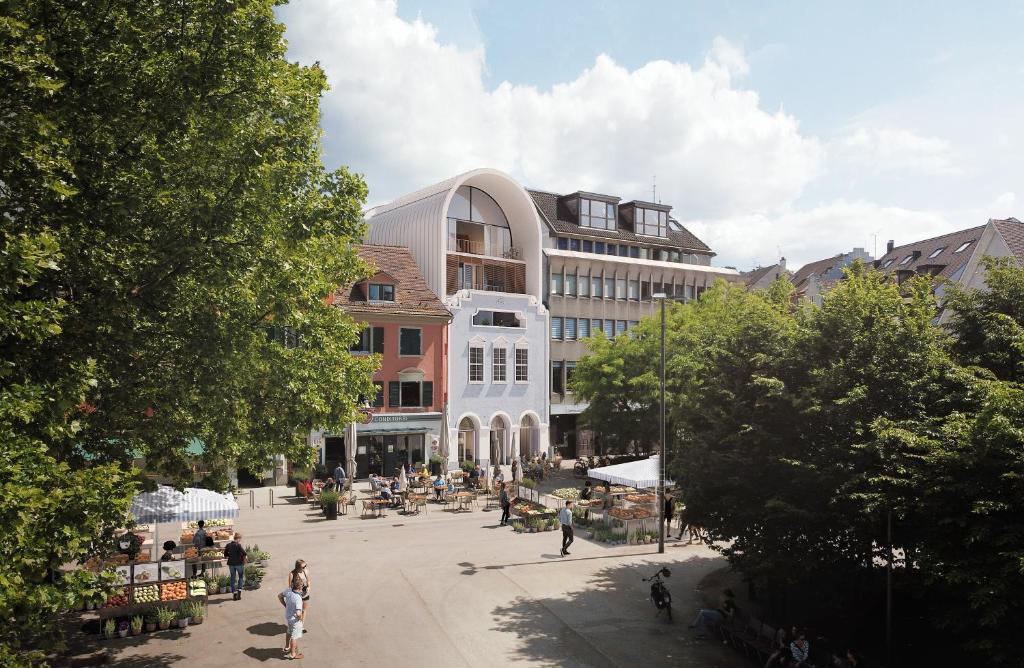 een groep mensen op een plein voor een gebouw bij kleiner Löwe – Stadthotel Bregenz in Bregenz