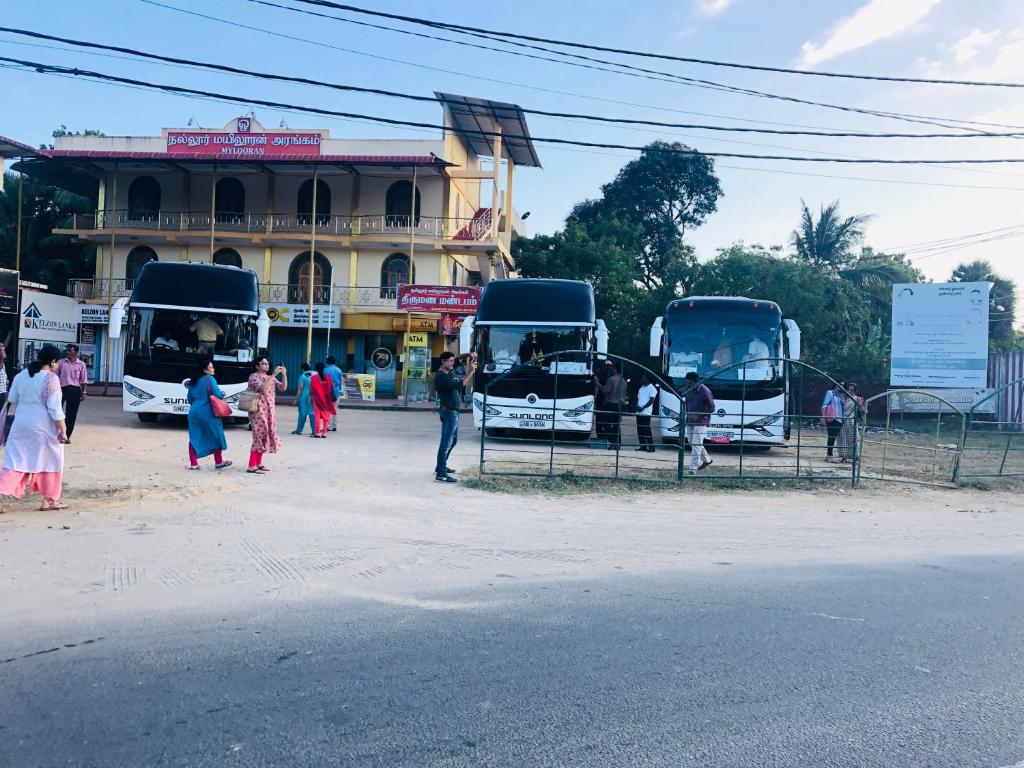 een groep mensen die voor twee bussen staan bij Nallur Mylooran Arangam in Jaffna