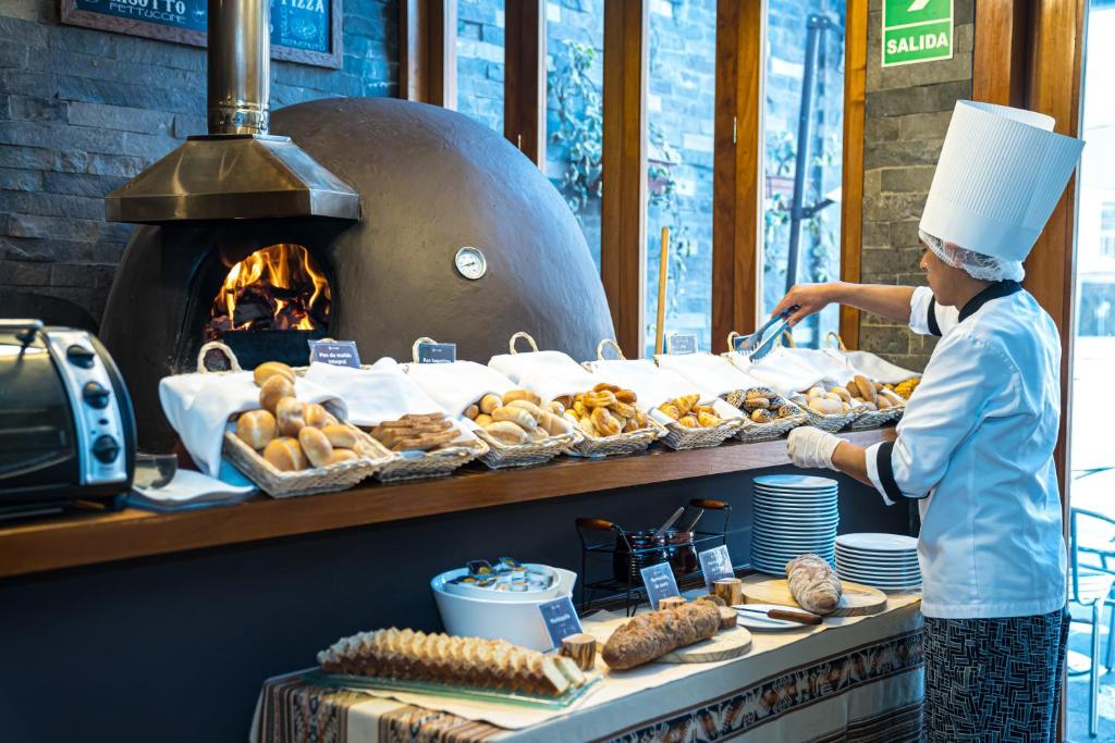 un chef que prepara comida frente a un horno en Sonesta Hotel Cusco, en Cusco