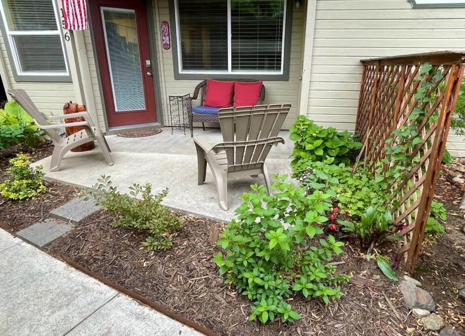 une terrasse couverte avec 2 chaises et un banc sur une maison dans l'établissement Hidden Gem in SE Boise with hot tub and wood burning fireplace, à Boise