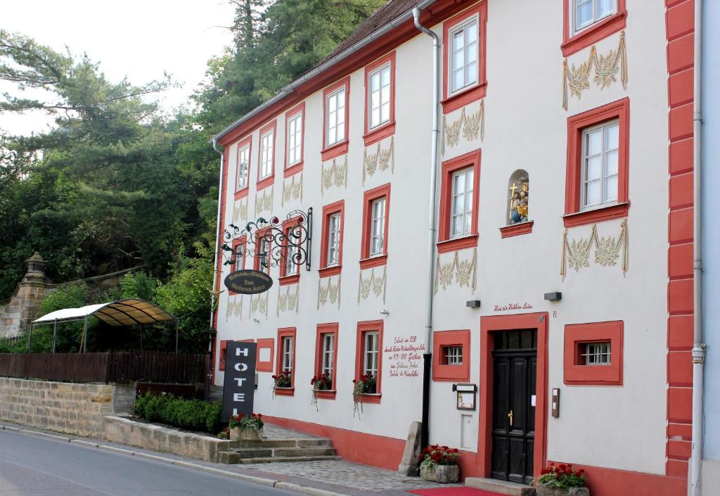 un edificio rosso e bianco sul lato di una strada di Hotel Zum Goldenen Anker a Bamberga