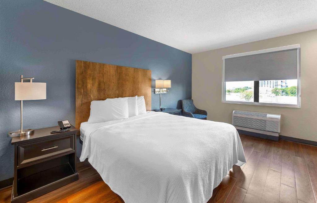 - une chambre avec un grand lit blanc et une fenêtre dans l'établissement Extended Stay America Premier Suites - Fort Lauderdale - Convention Center - Cruise Port, à Fort Lauderdale