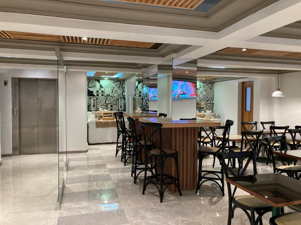 un bar in un ristorante con sedie e tavoli di Hotel Gavina Express ad Arica