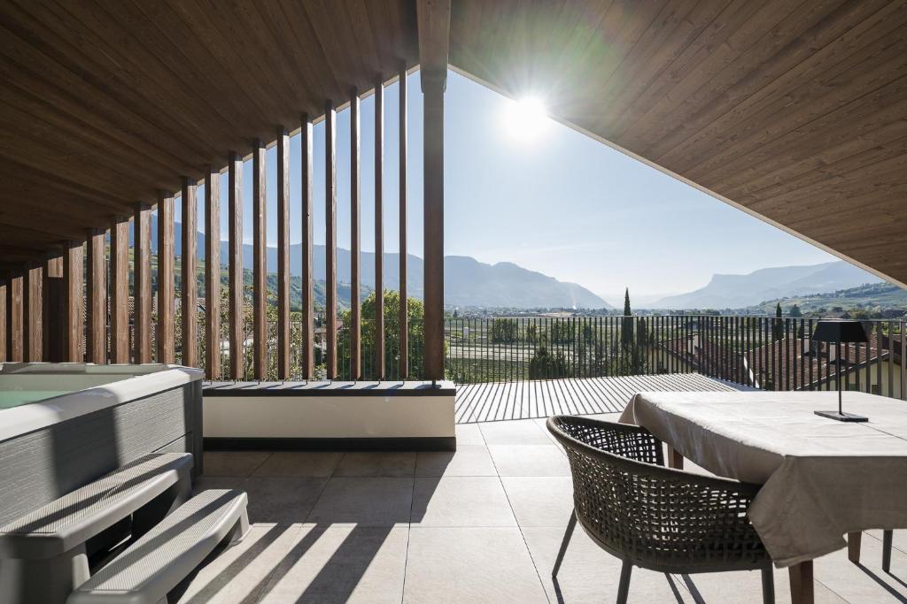 een kamer met een tafel en stoelen en een groot raam bij Apartsuites Rosengarten - New in Lagundo