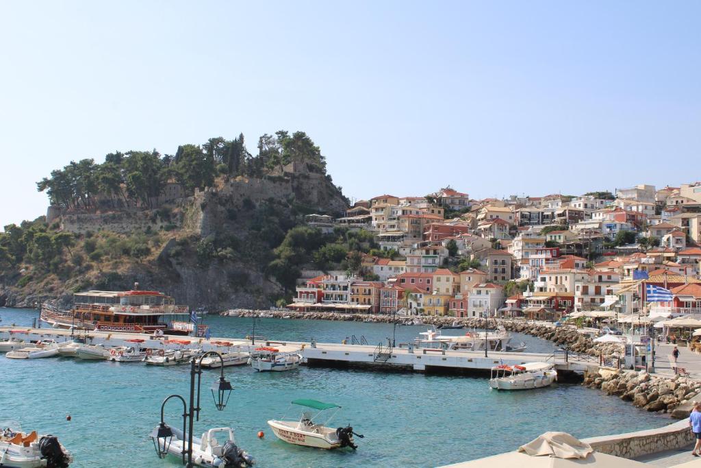 eine Gruppe von Booten, die in einem Hafen mit Häusern angedockt sind in der Unterkunft PARALIA Stoudios in Parga