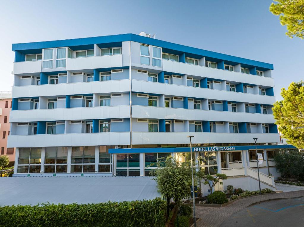 ein Apartmenthaus mit blauen Balkonen und einem Straßenschild in der Unterkunft Hotel Las Vegas in Bibione