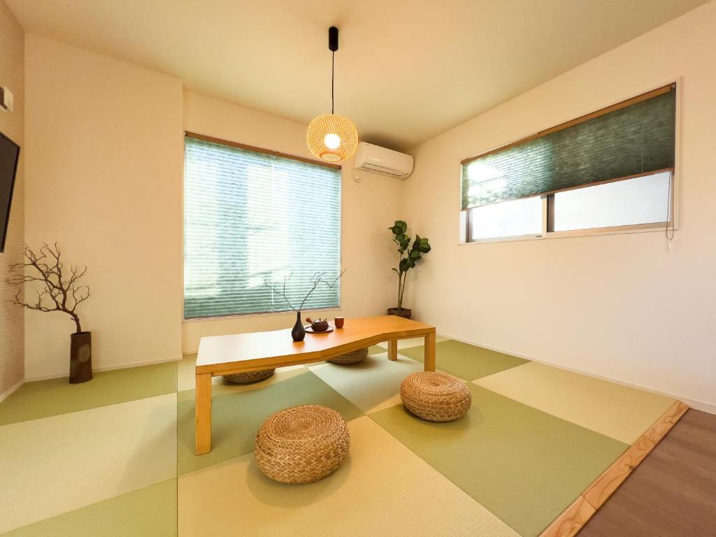 - un salon avec une table et deux tabourets dans l'établissement 大吉屋日赤館貸切一軒家旅館新築名古屋駅圏内, à Nagoya