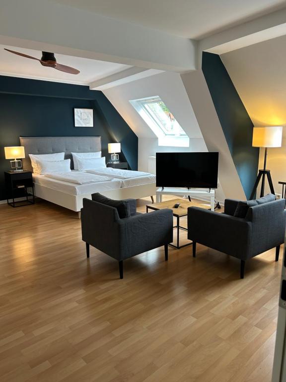 - une chambre avec un lit, deux chaises et un piano dans l'établissement DK Hotel Deutscher Kaiser, à Heidelberg