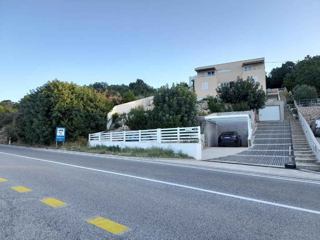 a house with a car parked on the side of a road at Apartmani NIKA in Dubrovnik