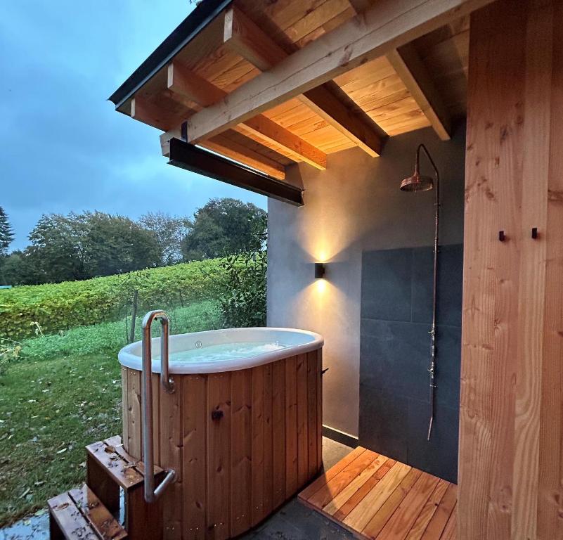 un bain à remous sur une terrasse sous un toit dans l'établissement Cabanes avec jacuzzi les pieds dans la vignes, 