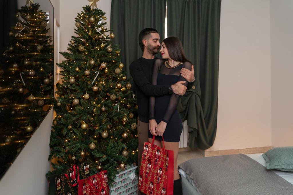 un hombre y una mujer de pie junto a un árbol de Navidad en Palazzo Marzionna, en Polignano a Mare