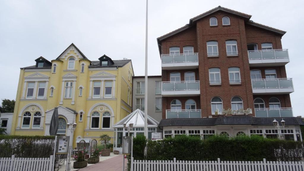 un grupo de edificios junto a una valla blanca en Hotel Sylter Hof, en Westerland