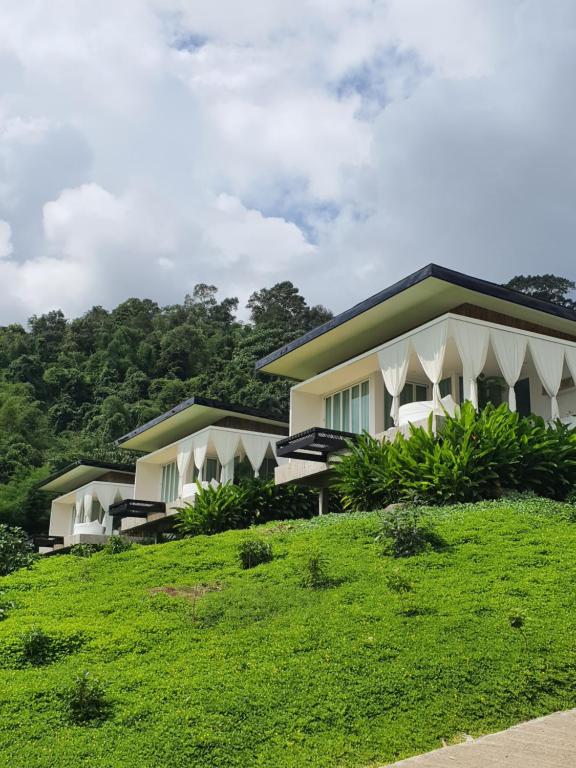 eine Reihe von Häusern auf einem grasbewachsenen Hügel in der Unterkunft เฌอปือ เชียงใหม่ Cherpue Chiangmai 