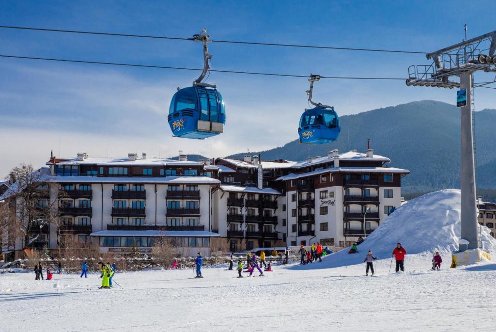 eine Gruppe von Menschen, die einen Skilift im Schnee fahren in der Unterkunft MPM Hotel Sport Ski-in, Ski-out in Bansko