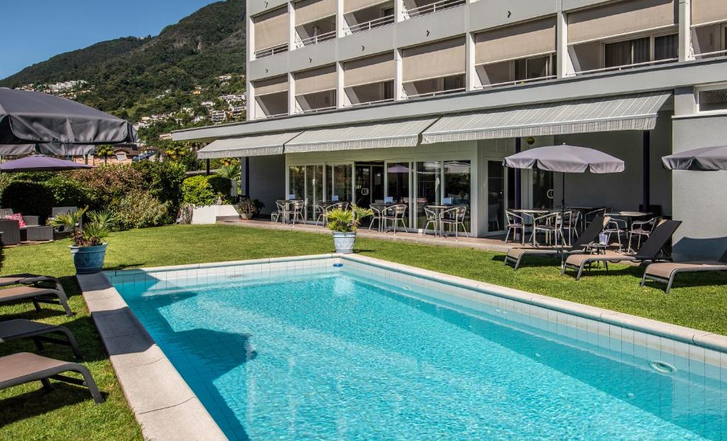 uma piscina em frente a um hotel em Smart-HOTEL MINUSIO, a Benvenuti Hotel em Locarno