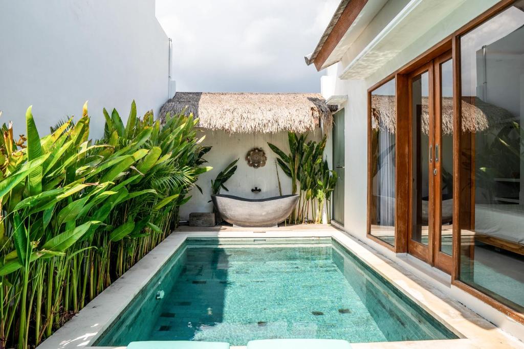 - une salle de bains pourvue d'une baignoire à côté d'une maison dans l'établissement KIKI VILLAGE PADDY FIELD, à Canggu