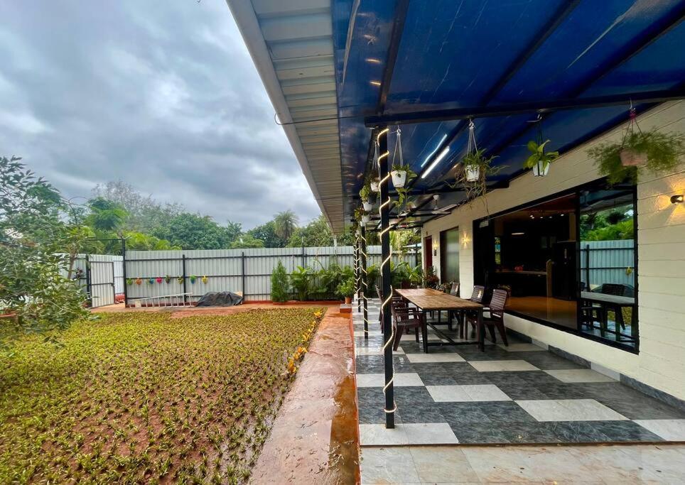 una casa con patio con mesa y sillas en Cloud9 Villa (Yeoor Hills, Thane) - A Luxurious Private Jungle Villa., en Thane