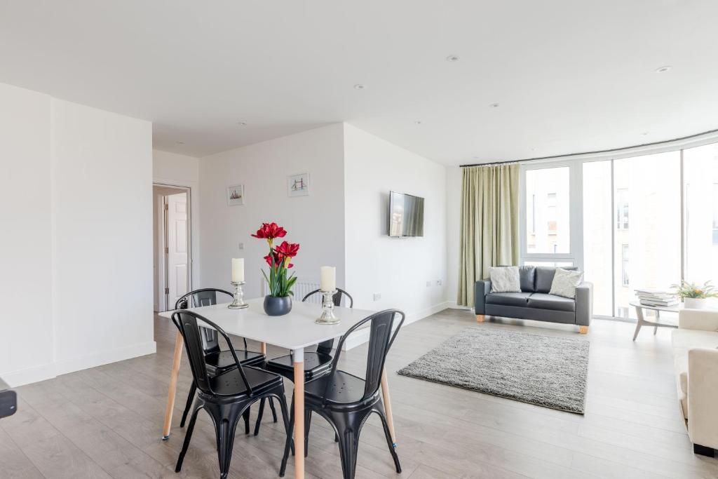 comedor y sala de estar con mesa y sillas en Boutique Vertigo Apartment Central Kingston/London, en Kingston upon Thames