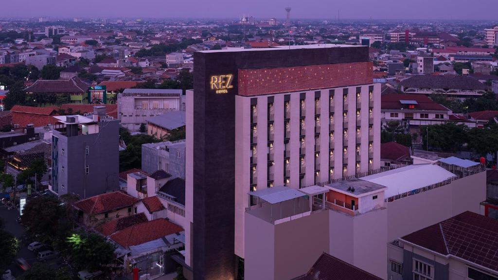 um edifício alto com um relógio na lateral em REZ Hotel em Semarang