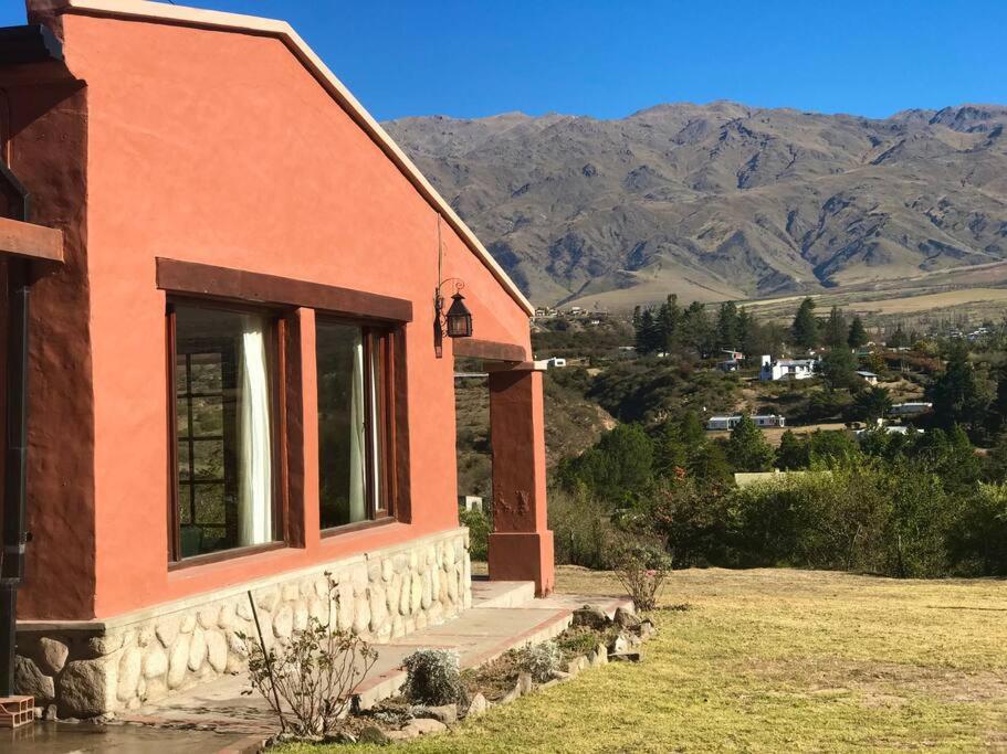 una casa arancione con montagne sullo sfondo di Lindísima Casa en Tafí del Valle a Tafí del Valle