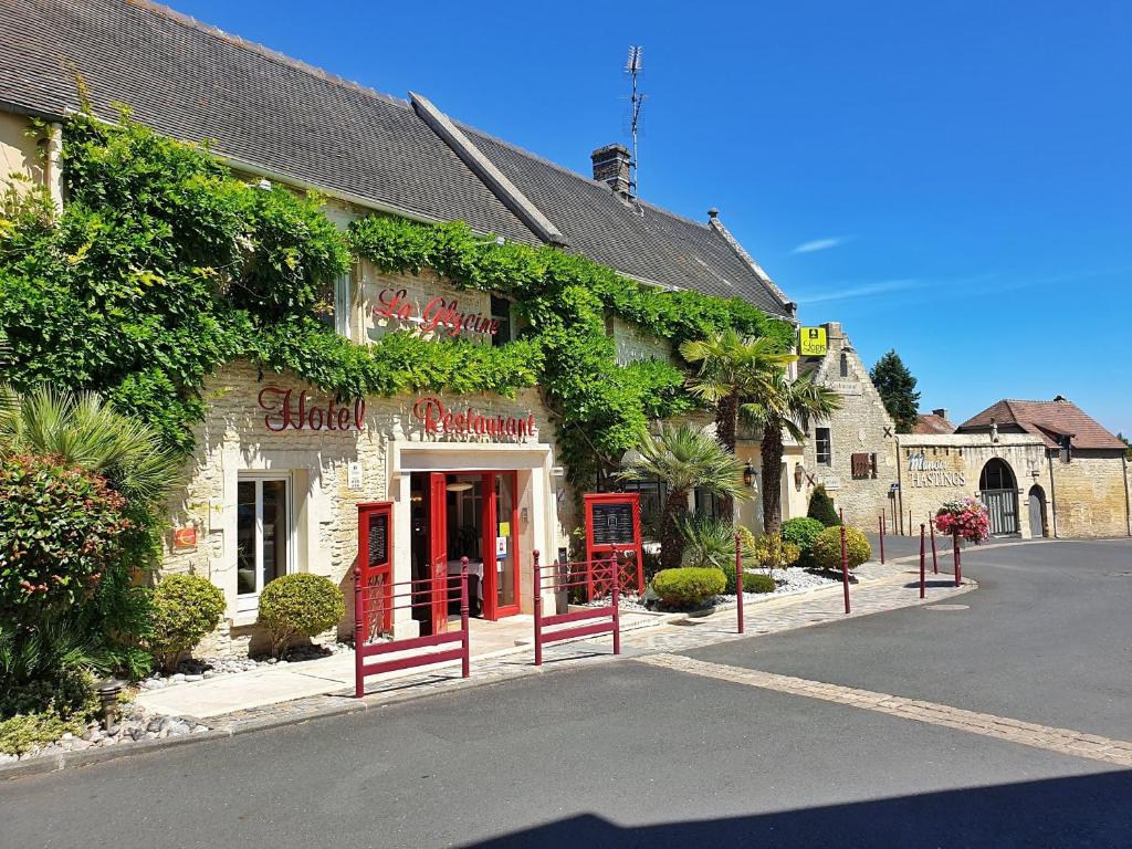 um edifício com portas vermelhas no lado de uma rua em La glycine hotel et spa em Bénouville