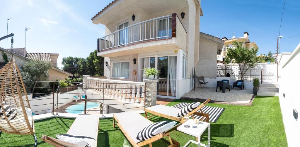 a house with a yard with chairs and a pool at VILLA WINE & BEACH Design and Luxury in Cala Crancs in Salou